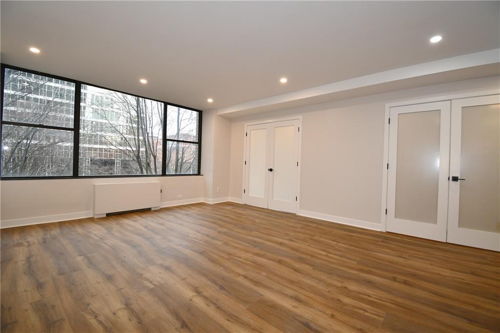 112 Washington Place, Unit 2G Pittsburgh, PA 15219 - Photo 12 of 26 wooden floor in an empty room with a window