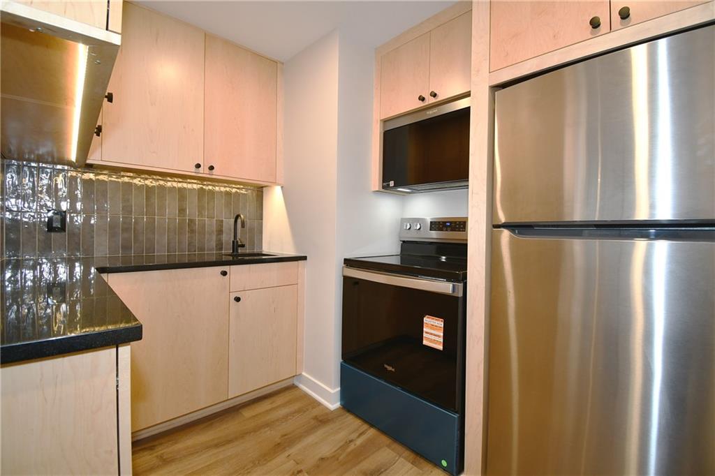 112 Washington Place, Unit 2G Pittsburgh, PA 15219 - Photo 14 of 26 a kitchen with stainless steel appliances a refrigerator and a microwave