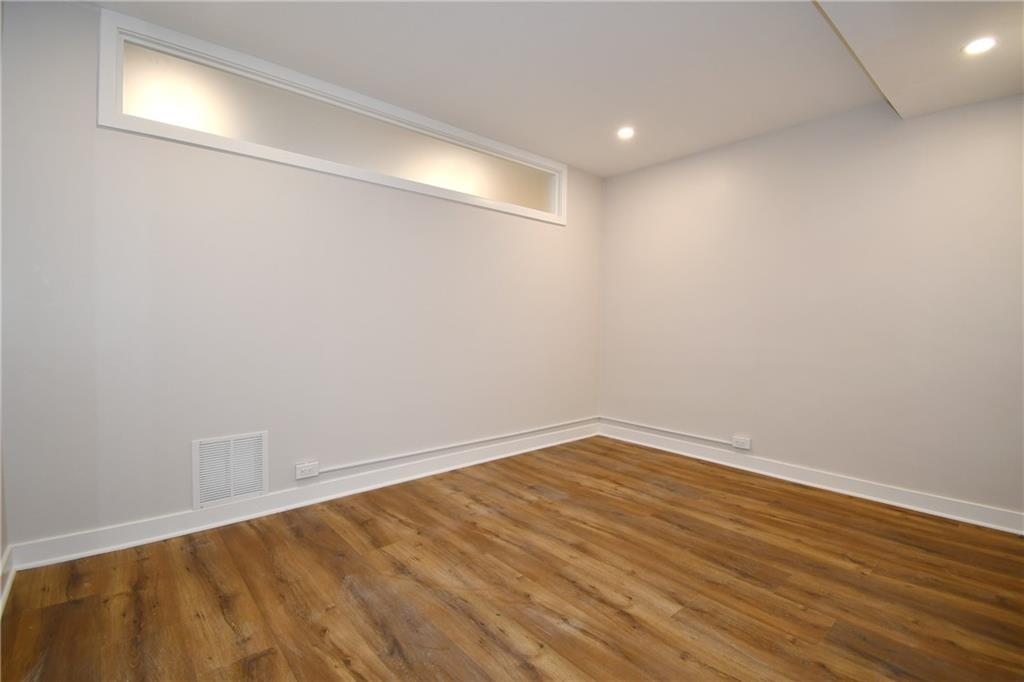 112 Washington Place, Unit 2G Pittsburgh, PA 15219 - Photo 16 of 26 a view of an empty room with wooden floor and a window