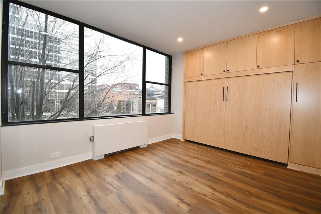 112 Washington Place, Unit 2G Pittsburgh, PA 15219 - Photo 18 of 26 an empty room with wooden floor and windows