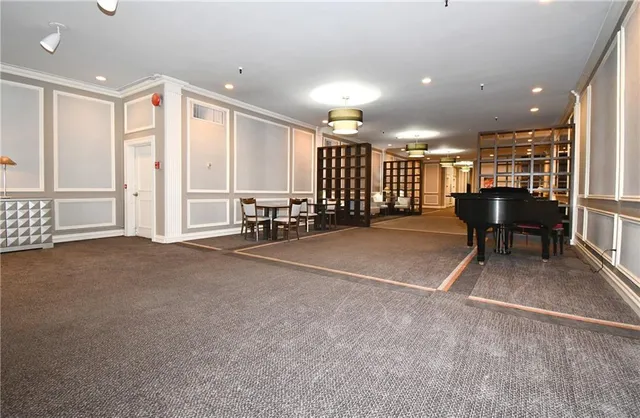 a view of an empty room with furniture and a window