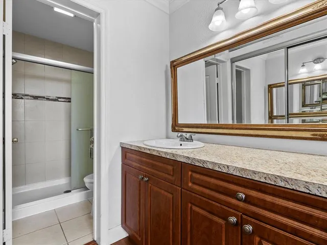a bathroom with a granite countertop sink and a mirror