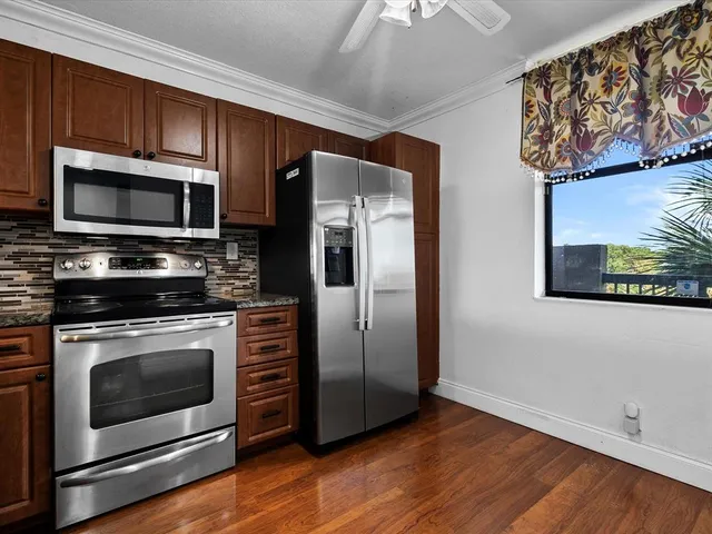 a kitchen with stainless steel appliances and wooden cabinets