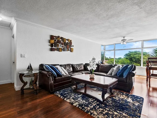 a living room with furniture a rug and a large window