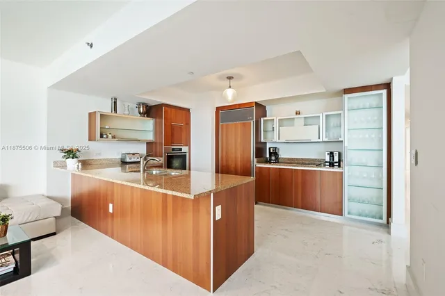 a kitchen with stainless steel appliances granite countertop a refrigerator a stove a sink and a microwave