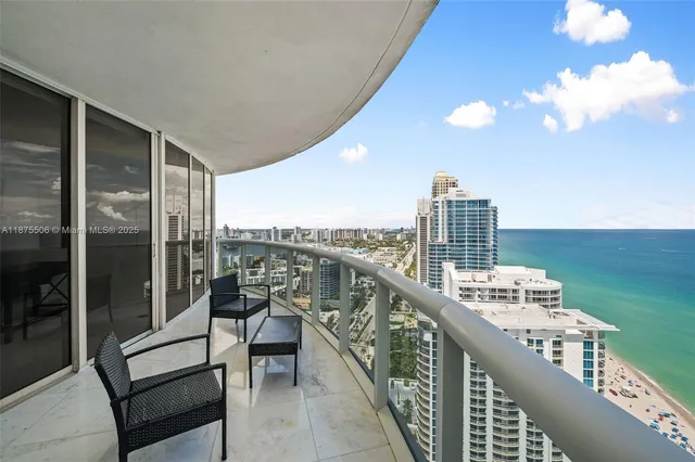 a balcony with wooden floor and outdoor seating