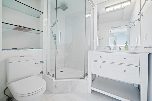 a bathroom with a granite countertop sink a toilet and shower