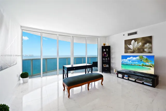 a living room with furniture a flat screen tv and floor to ceiling window