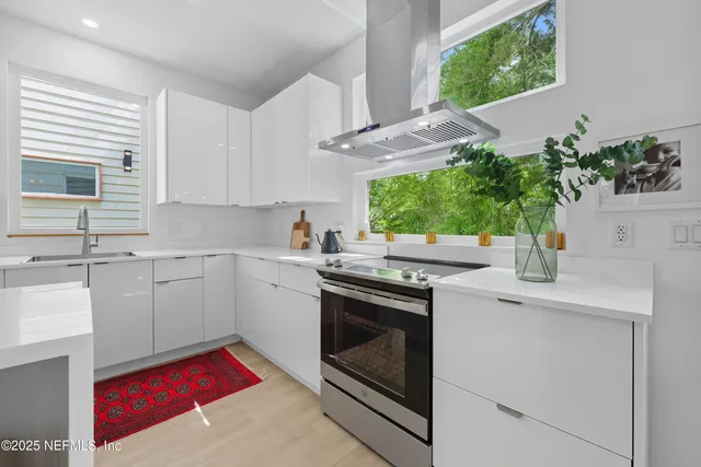 a kitchen with stainless steel appliances white cabinets and a stove top oven