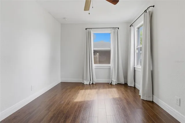 an empty room with wooden floor and a window