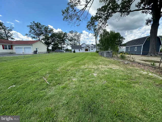 a view of a house with a big yard and large tree