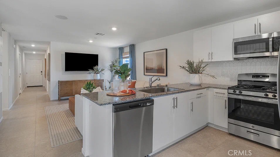 79327 Valor Lane Indio, CA 92203 - Photo 3 of 19 a kitchen with stainless steel appliances granite countertop a stove top oven a sink a microwave a refrigerator and cabinets