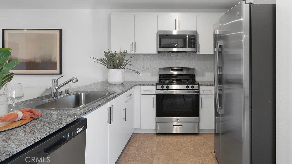 79327 Valor Lane Indio, CA 92203 - Photo 5 of 19 a kitchen with granite countertop a sink and a stove top oven