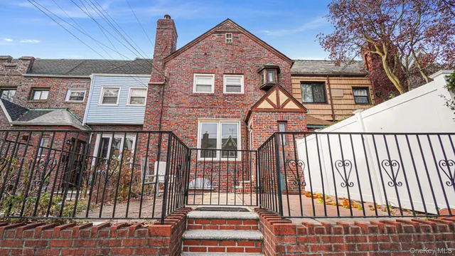 a view of a brick house with wooden fence