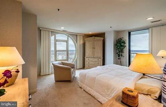 a bedroom with a bed and large windows