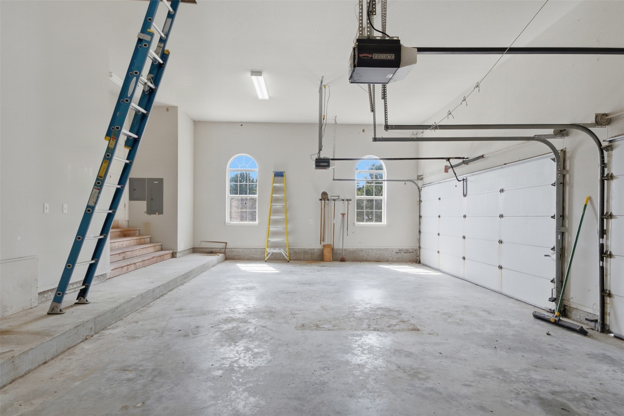 17875 East 589 Road Inola, OK 74036 - Photo 34 of 73 Spacious three car garage with an automatic overhead door, concrete flooring, arched windows, and overhead lighting