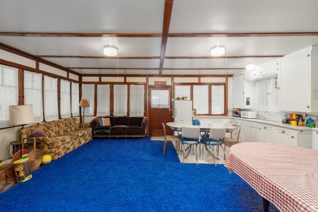 6449 North North Fork Road Eden, UT 84310 - Photo 11 of 38 Expansive room featuring a blue carpet, white walls, and exposed wood beams