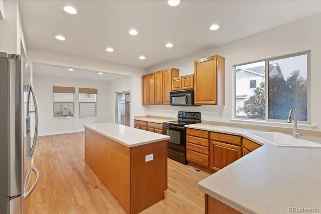 a kitchen with stainless steel appliances granite countertop a sink a stove and a refrigerator