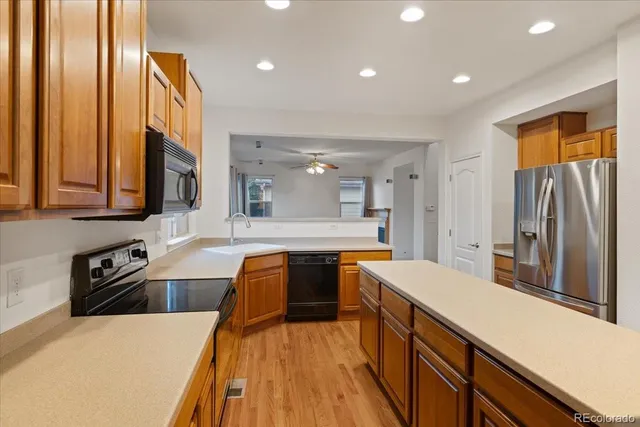 a large kitchen with stainless steel appliances lots of counter space and wooden floor