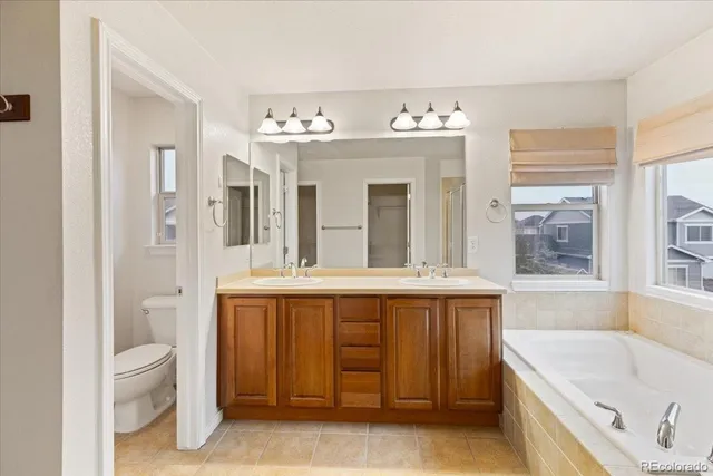 a spacious bathroom with a tub sink and mirror