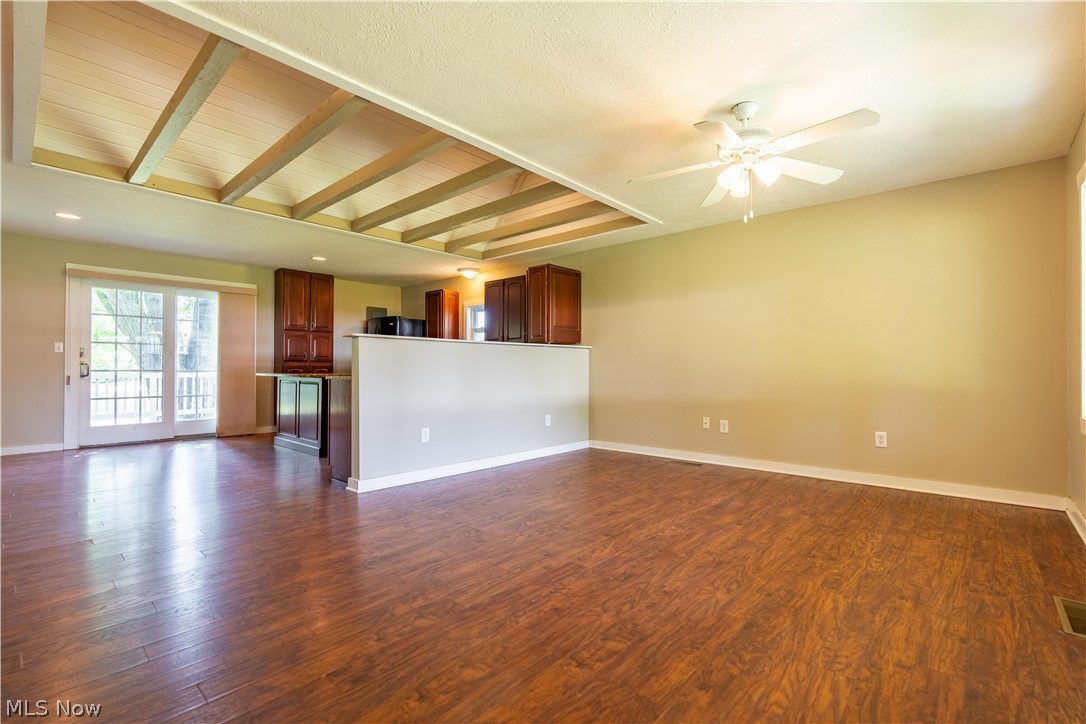 1889 Ronald Road Akron, OH 44312 - Photo 11 of 36 Unfurnished room featuring beamed ceiling, ceiling fan, and dark hardwood / wood-style flooring