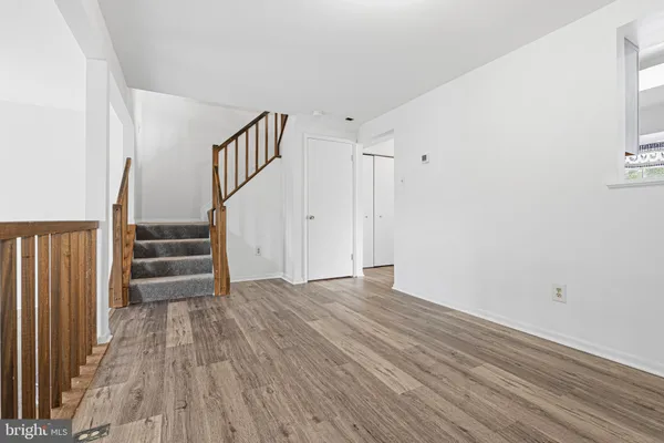 a view of empty room with stairs and wooden floor