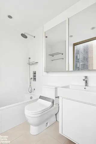 a bathroom with a granite countertop sink a toilet and shower
