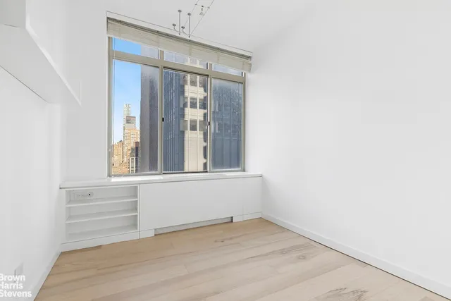 a spacious bedroom with a bed and a large mirror