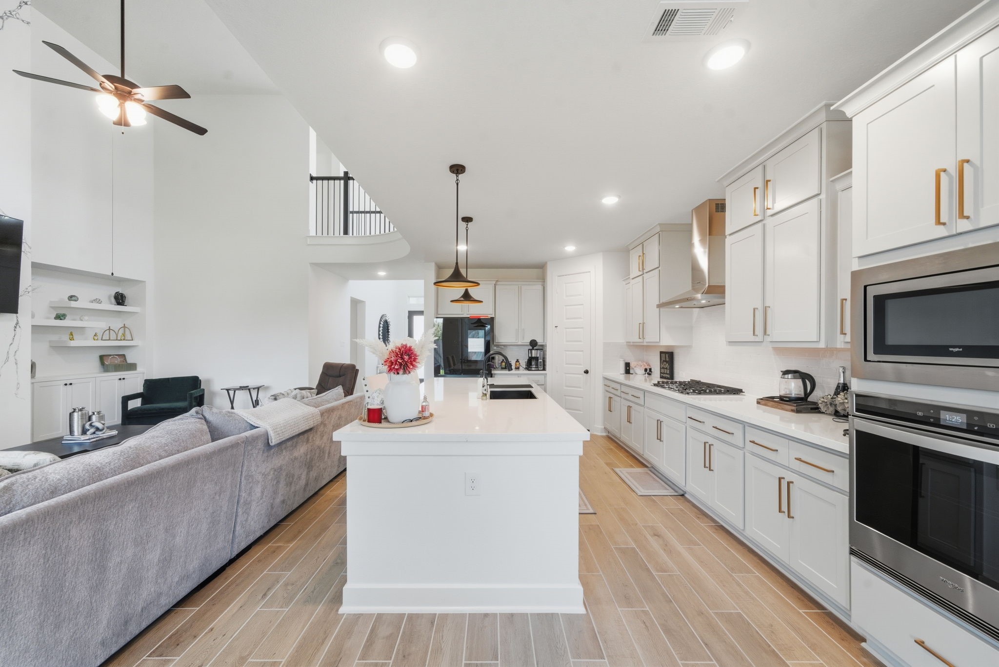 10438 Rigel Rdg Way Richmond, TX 77406 - Photo 12 of 34 a kitchen with stainless steel appliances a stove a sink dishwasher a refrigerator and white cabinets with wooden floor