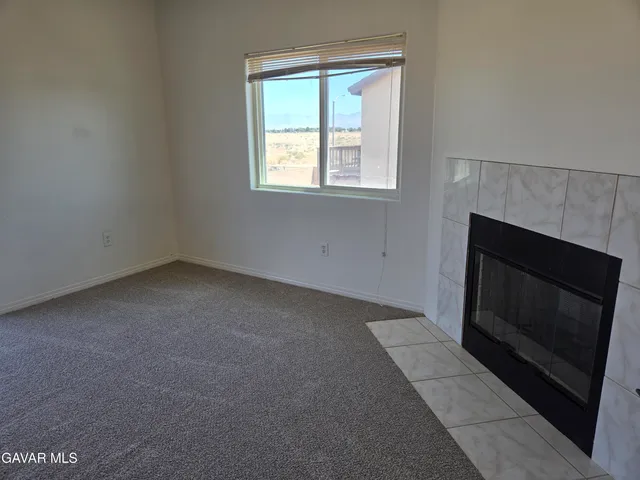 a view of an empty room with closet and mirror