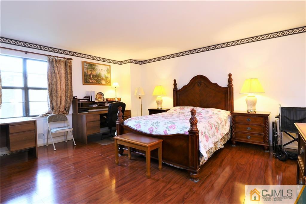 6801 Hana Road Edison, NJ 08817 - Photo 14 of 24 a spacious bedroom with a bed and wooden floor