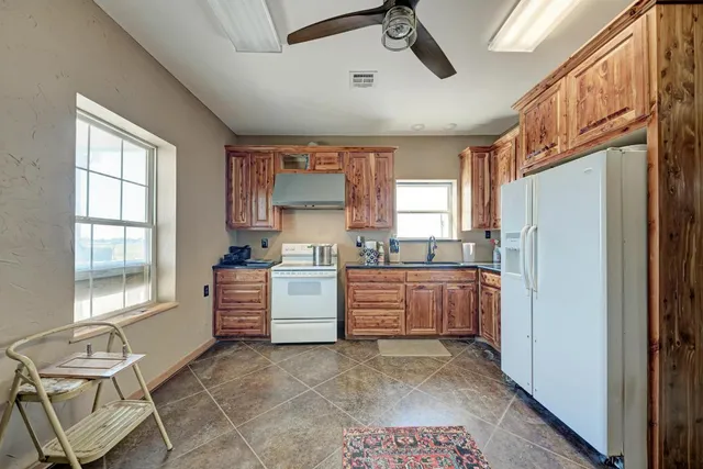a kitchen with sink refrigerator and window