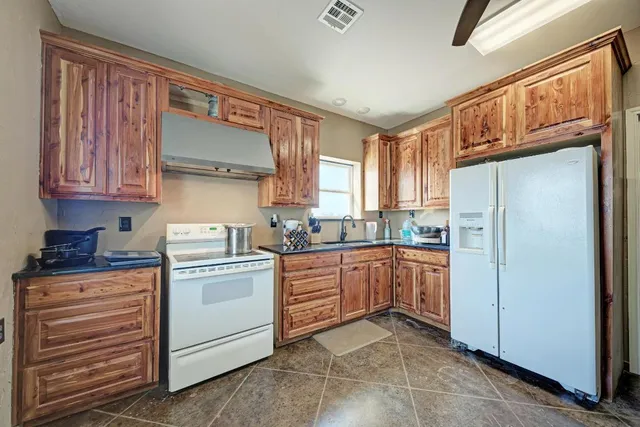 a kitchen with stainless steel appliances granite countertop a refrigerator and cabinets