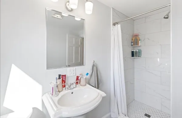 a bathroom with a sink a shower and a mirror