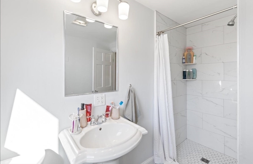 16 Atlantic Street Boston, MA 02127 - Photo 12 of 18 a bathroom with a sink a shower and a mirror