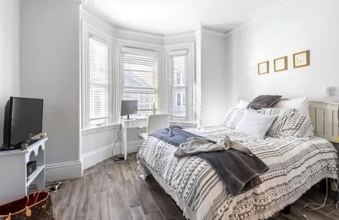 a bed sitting in a bedroom next to a window