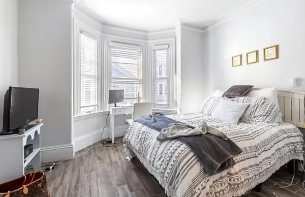 a bed sitting in a bedroom next to a window