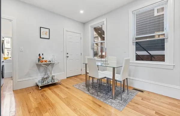 a dining room with wooden floor and a table