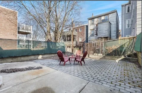 a view of a brick building with a bench in the patio