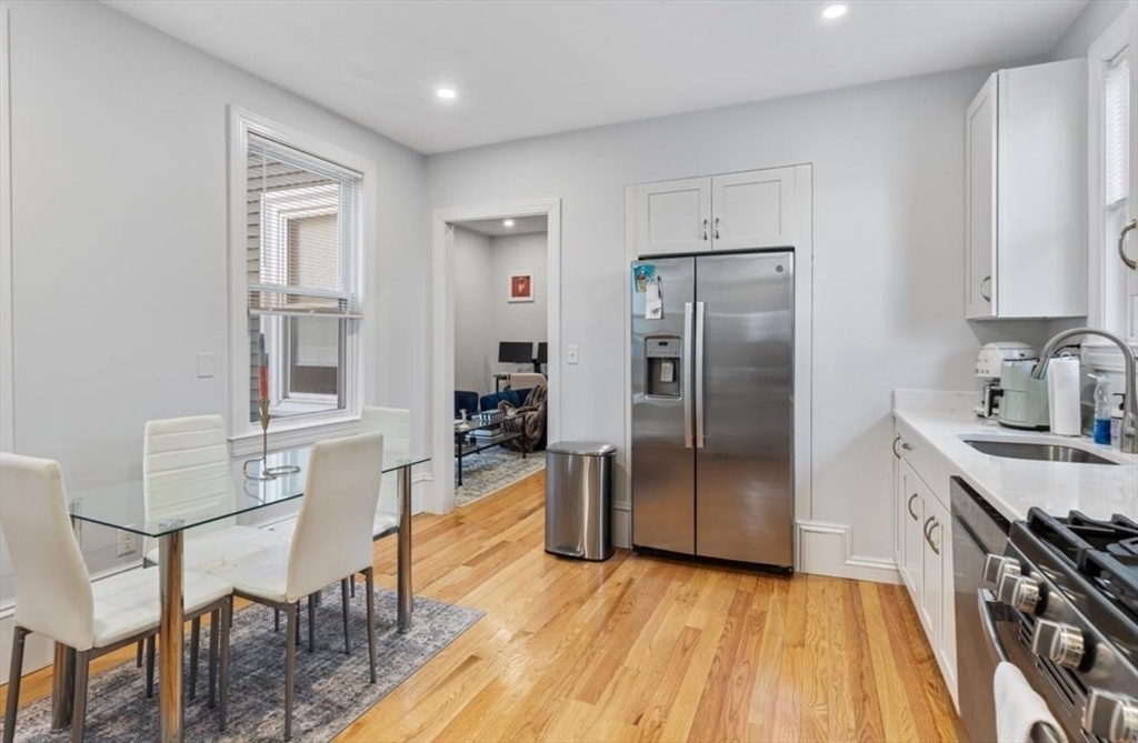 16 Atlantic Street Boston, MA 02127 - Photo 6 of 18 a kitchen with stainless steel appliances granite countertop a refrigerator a stove a sink dishwasher and a dining table with wooden floor