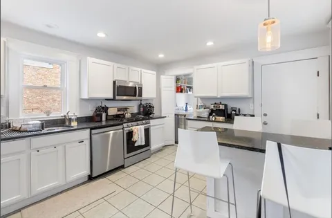 a kitchen with granite countertop white cabinets and white appliances