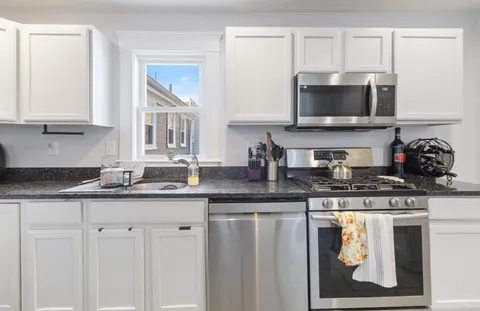 a kitchen with stainless steel appliances granite countertop a sink a stove and microwave