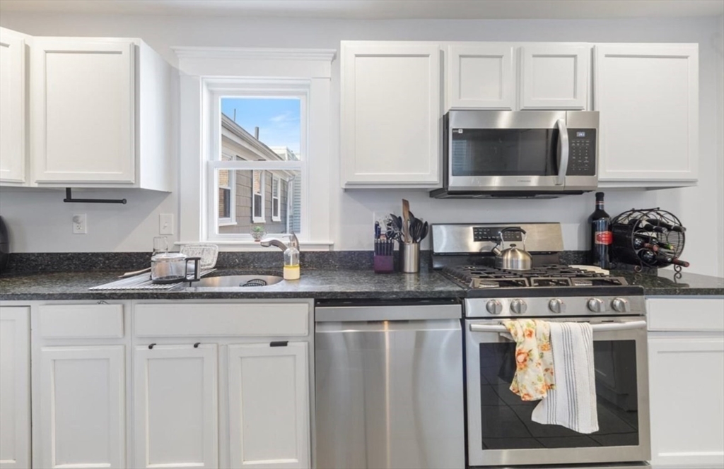 16 Atlantic Street Boston, MA 02127 - Photo 10 of 18 a kitchen with stainless steel appliances granite countertop a sink a stove and microwave