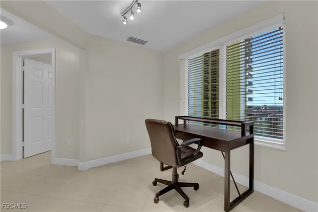 a view of a workspace with furniture and a window