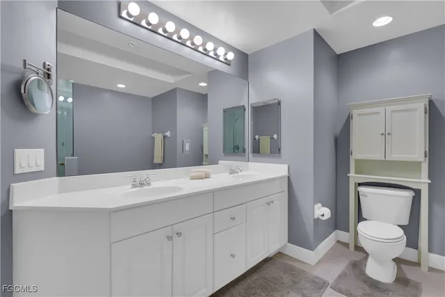 a bathroom with a toilet a sink and mirror