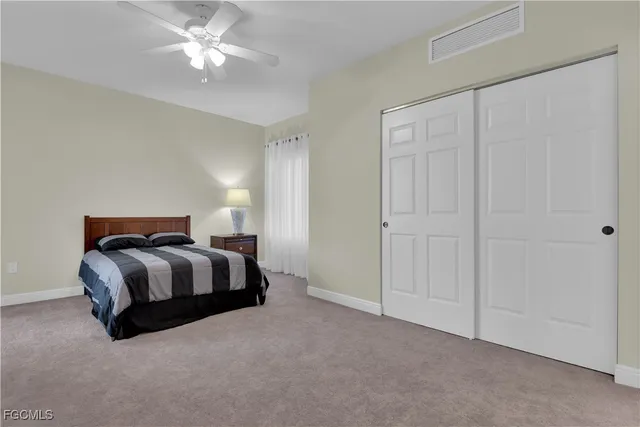 a spacious bedroom with a bed and a chandelier