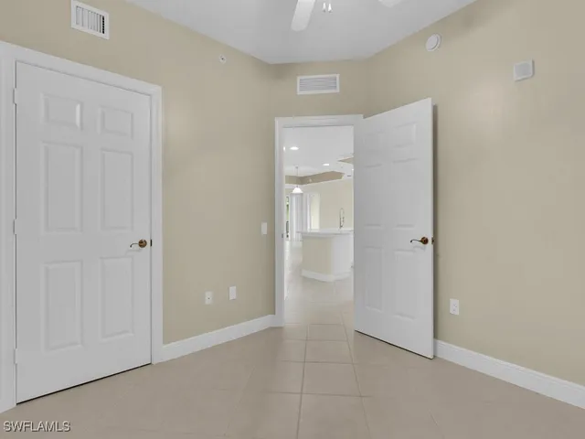 an empty room with closet and a bathroom