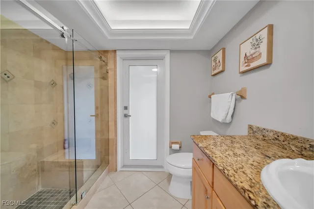 a bathroom with a granite countertop sink a toilet and shower