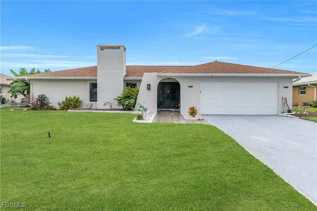a view of a house with a backyard and a tree