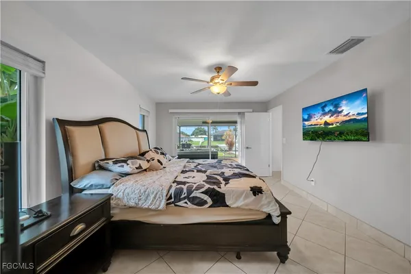 a bedroom with bed and a flat screen tv